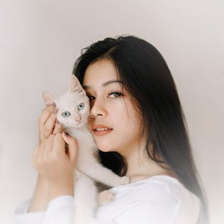 A pet owner holding her kitten.